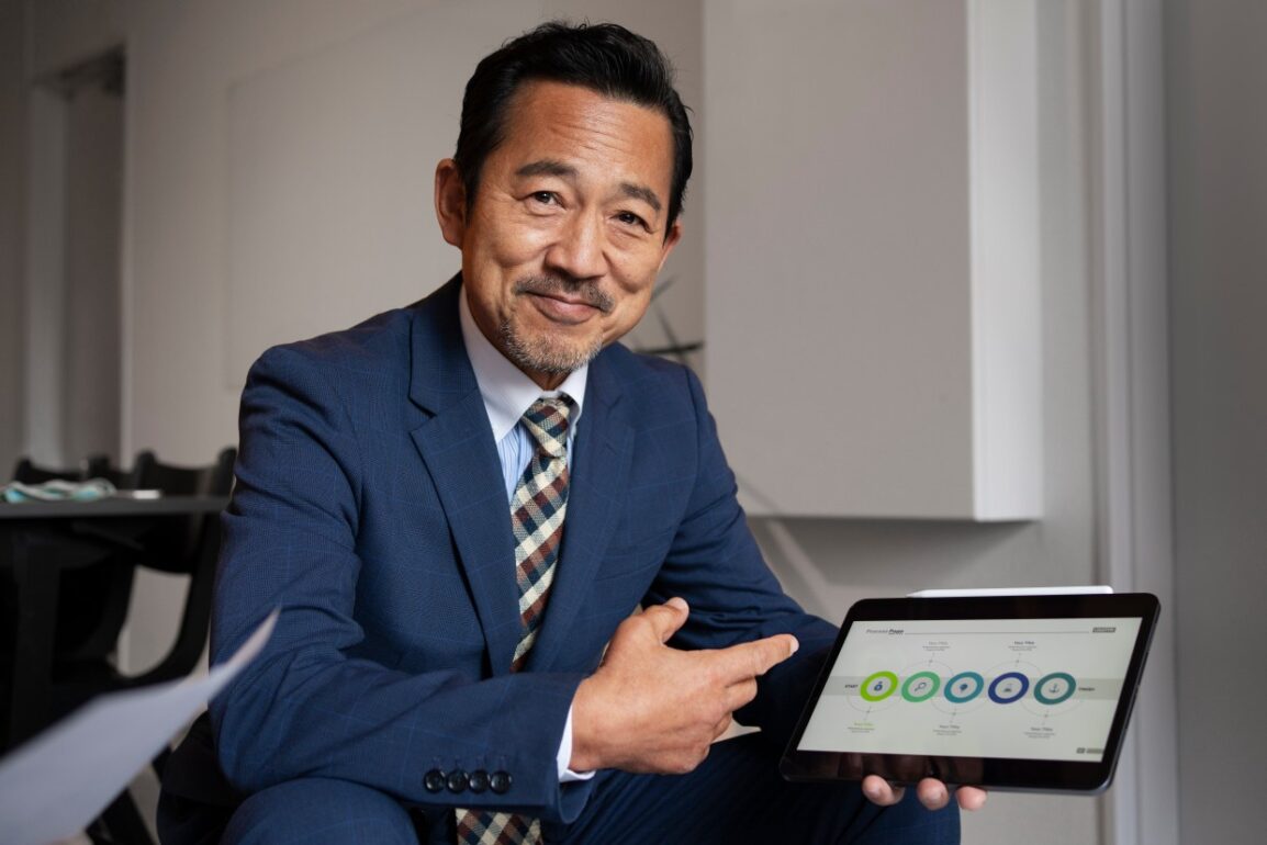 A happy business man showing his gps tracking dashboard to demonstrate how gps tracking help his business.